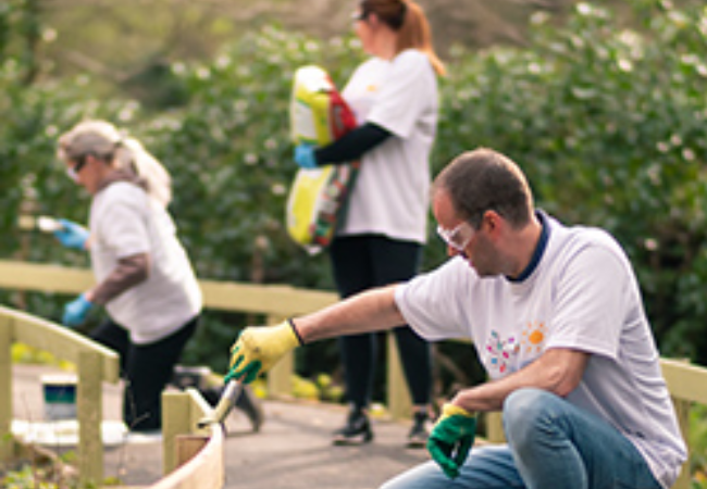 volunteers painting fence 