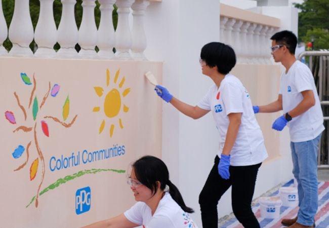 volunteers painting Colorful Communities wall mural 