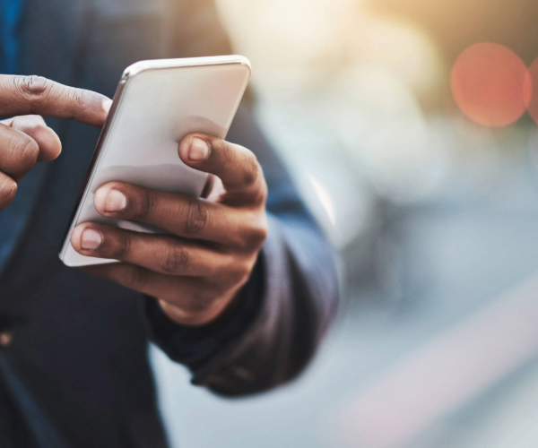 Silver phone being held by man in blue jacket