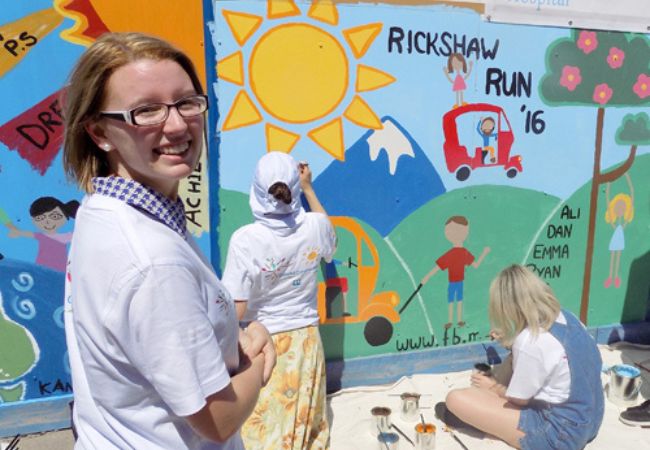 volunteers painting wall mural in Australia 