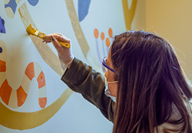 girl painting wall mural 