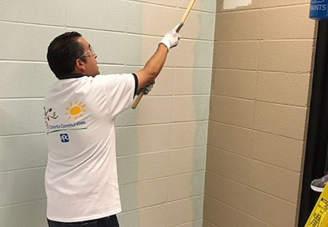 Man painting interior wall with roller