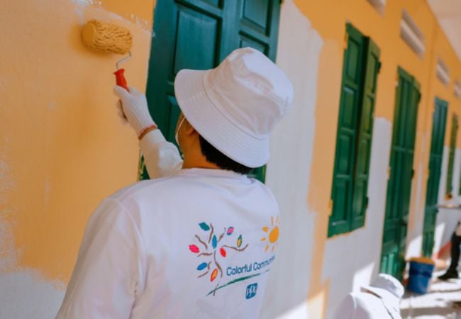 Man painting exterior wall in Yen Bai province, Vietnam