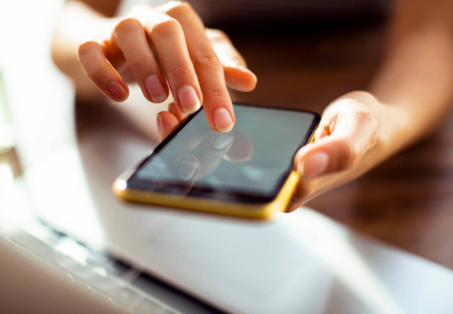 Persons hands with smartphone touching the screen