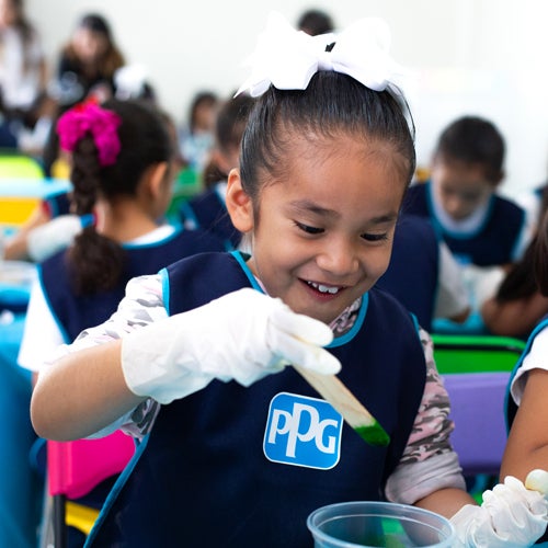 Young girl in PPG bib doing science experiment 