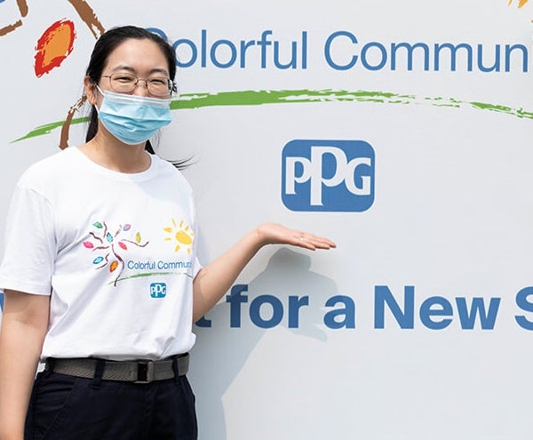 colorful communities volunteer next to PPG logo 