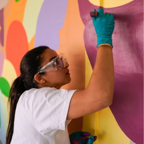 volunteer creating colorful mural