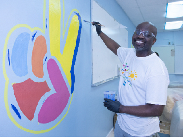 colorful communities volunteer painting colorful wall mural 
