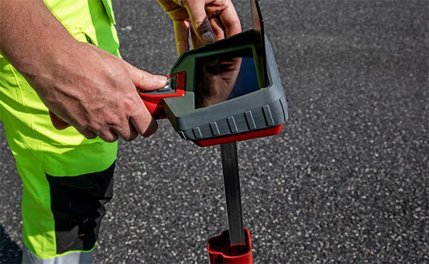 Worker measuring roadway markings