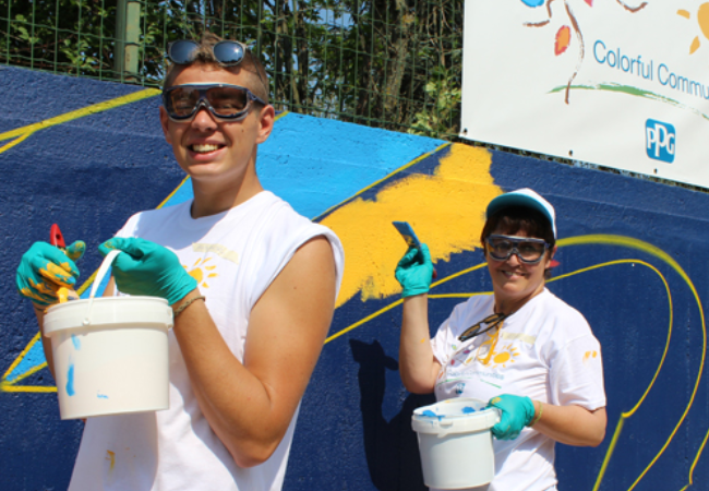 Two volunteers painting murals in Quattordio, Italy 