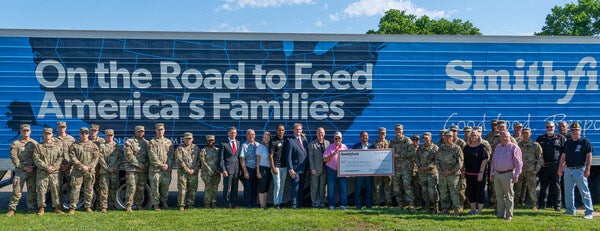 Tolcha Mesele, senior community development manager, Smithfield Foods, presents a donation check for more than 150,000 servings of food during Armed Forces Day Celebration event in Junction City, Kansas.