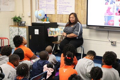 An Achievable Dream’s students listen attentively to Melissa Ferrell, talent development training specialist, Smithfield Foods, reading a book.