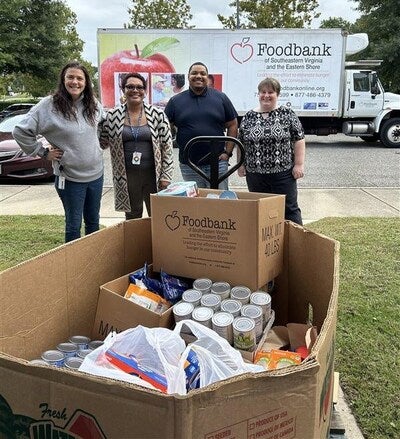 Left to right: Kat Gregory, senior fleet dispatcher, Smithfield Foods; AJ Mcrae, diversity, culture and engagement specialist, Smithfield Foods; Rashaun Chambers, senior fleet dispatcher, Smithfield Foods; and Rachel Alexander, associate customer service specialist, Smithfield Fields, load collected nonperishable items into the Foodbank of Southeast Virginia and the Eastern Shore’s truck.