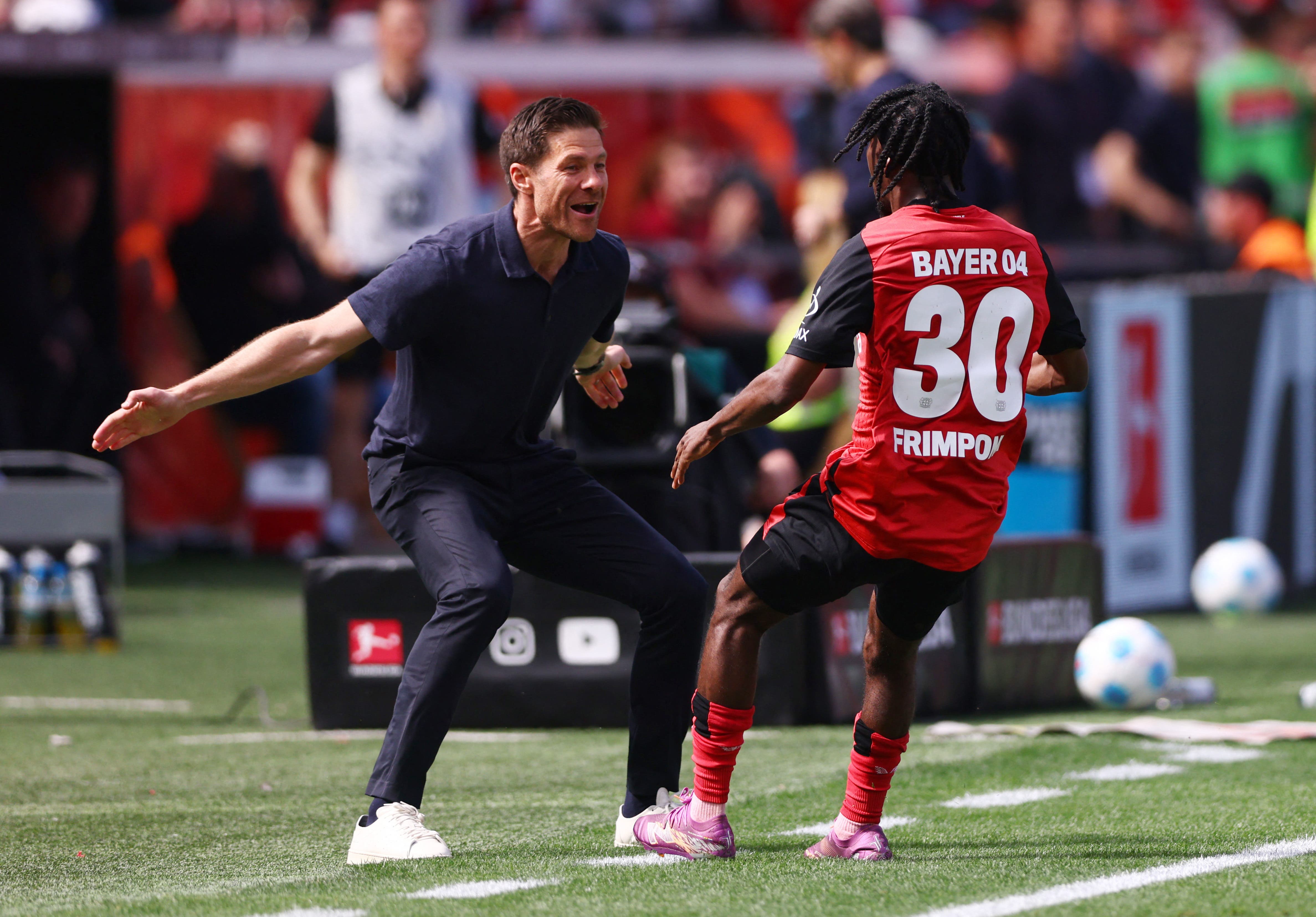 Soccer Football - Bundesliga - Bayer Leverkusen v Borussia Dortmund - BayArena, Leverkusen, Germany - May 11, 2025 Bayer Leverkusen's Jeremie Frimpong celebrates with coach Xabi Alonso after scoring their first goal REUTERS/Thilo Schmuelgen