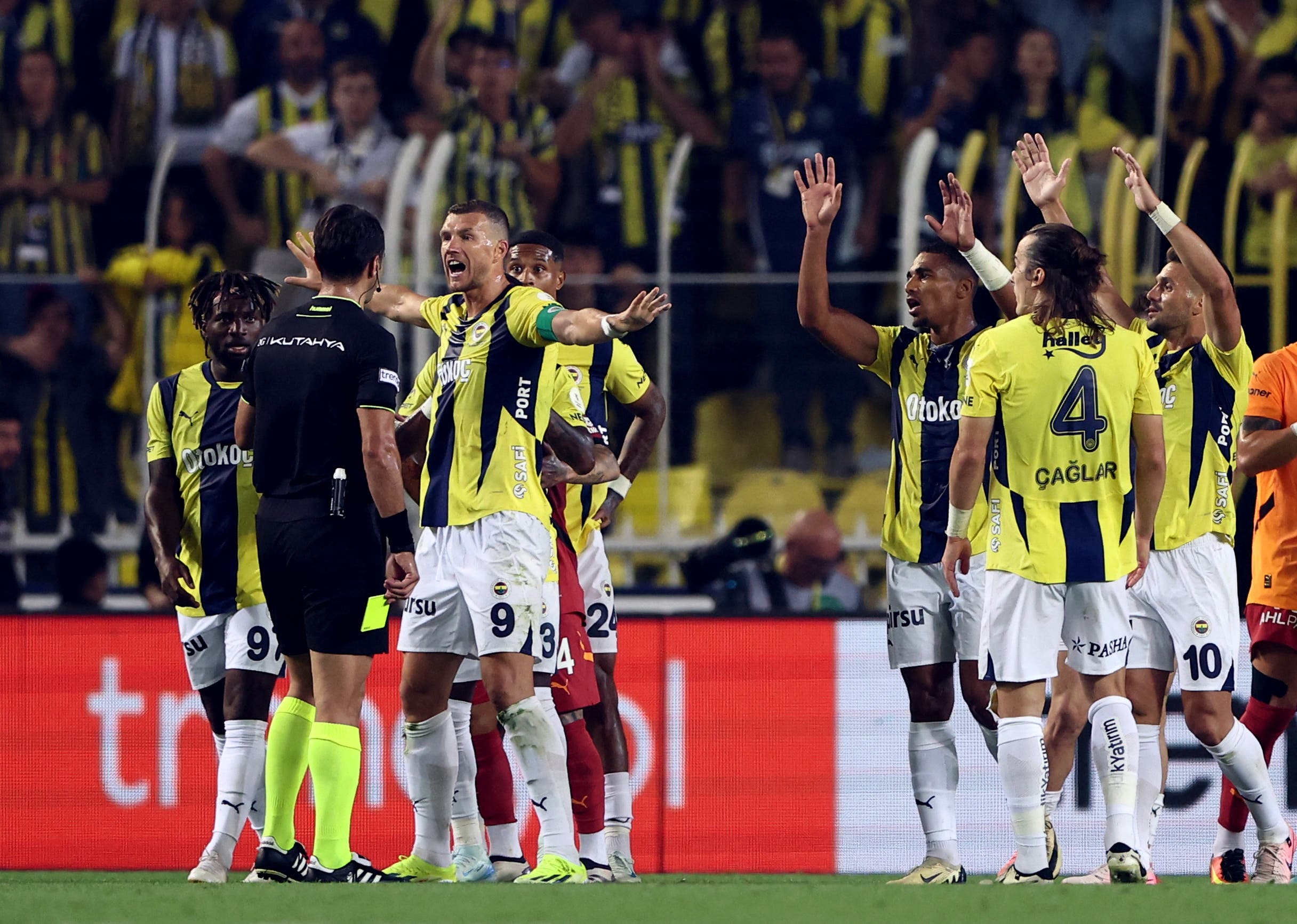 Fenerbahce's Edin Dzeko and teammates remonstrate with referee