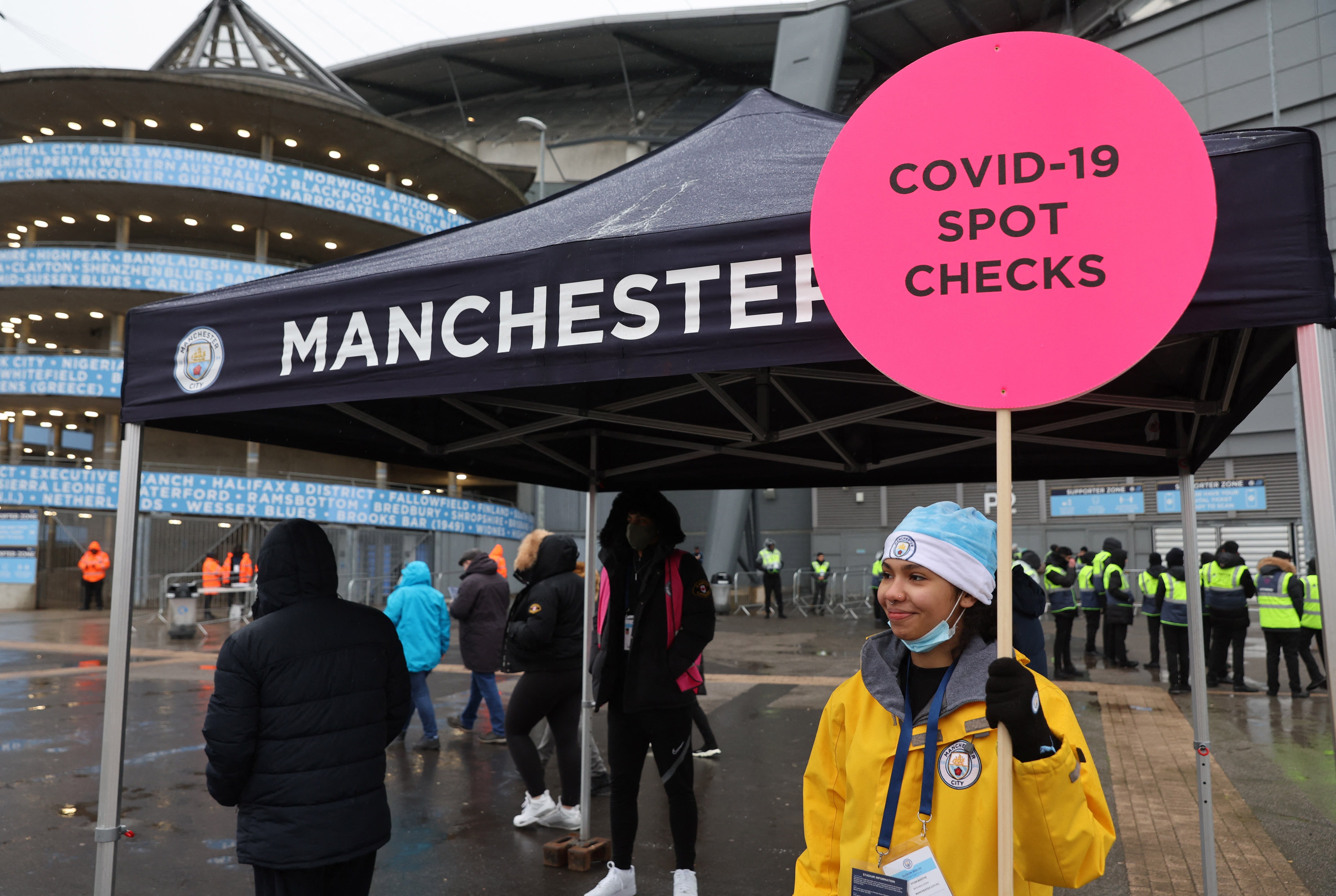 Manchester City Fans get their coronavirus disease (COVID-19) passes checked outside the stadium before the match