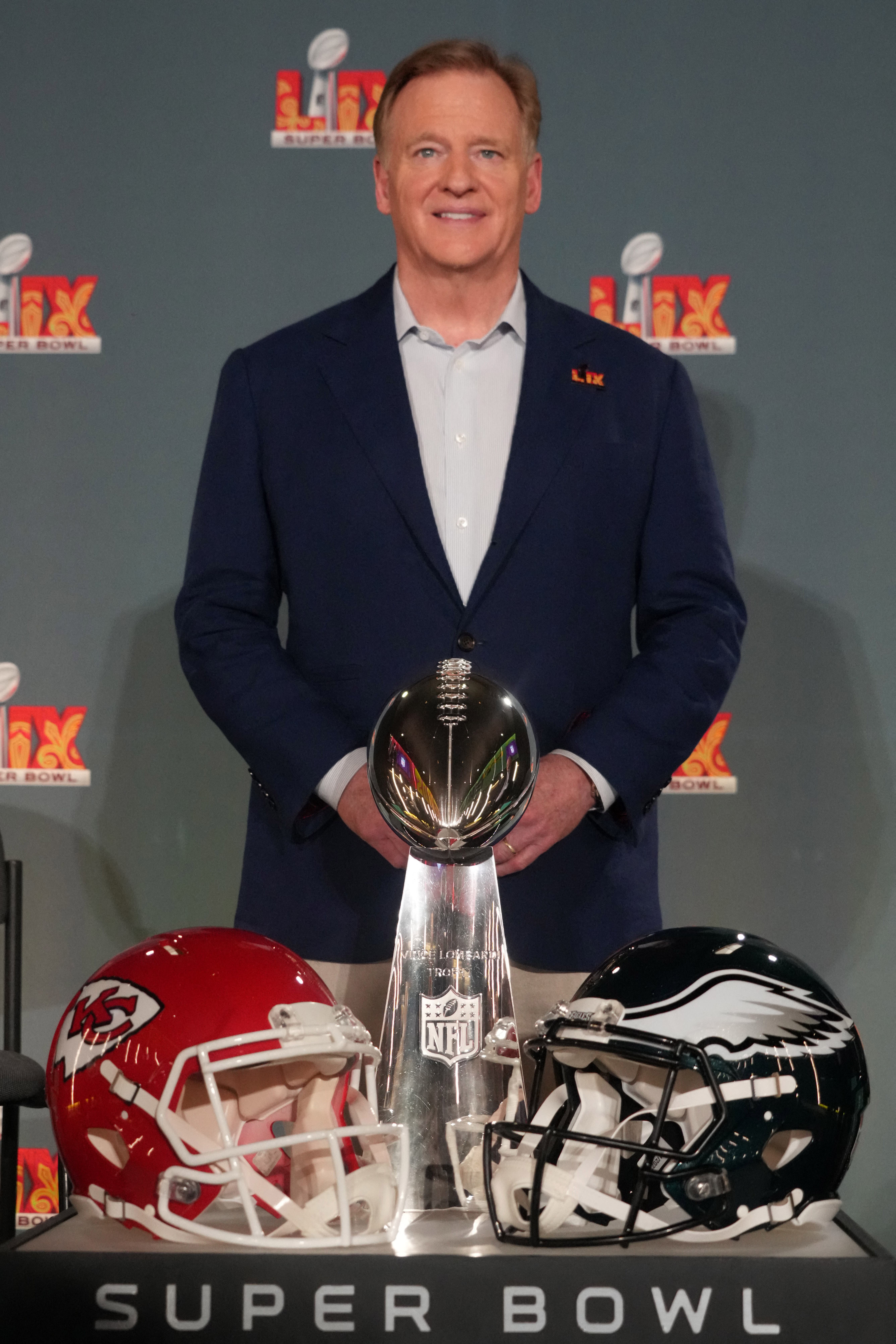 NFL commissioner Roger Goodell poses with Vince Lombardi trophy and Philadelphia Eagles and Kansas City Chiefs helmets at a press conference ahead of Super Bowl LIX at the Caesars Superdome.