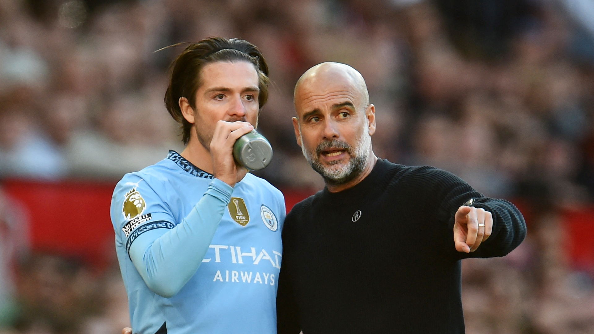Pep Guardiola talks with Jack Grealish before him entering a game with Manchester City.