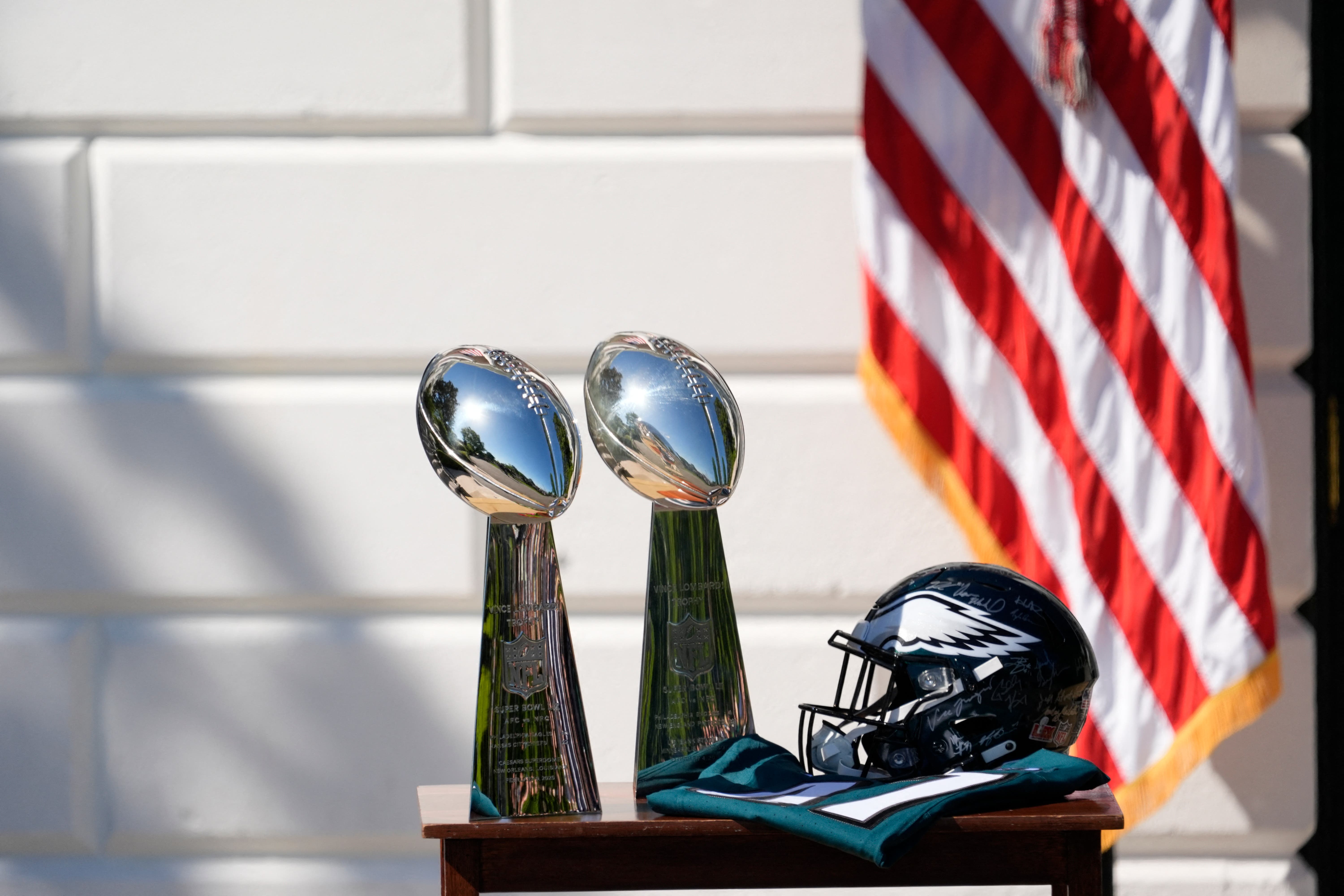 Two Vince Lombardi Trophies, a helmet and jersey on a table before President Donald Trump honors the Super Bowl LIX champion Philadelphia Eagles at The White House in Washington D.C