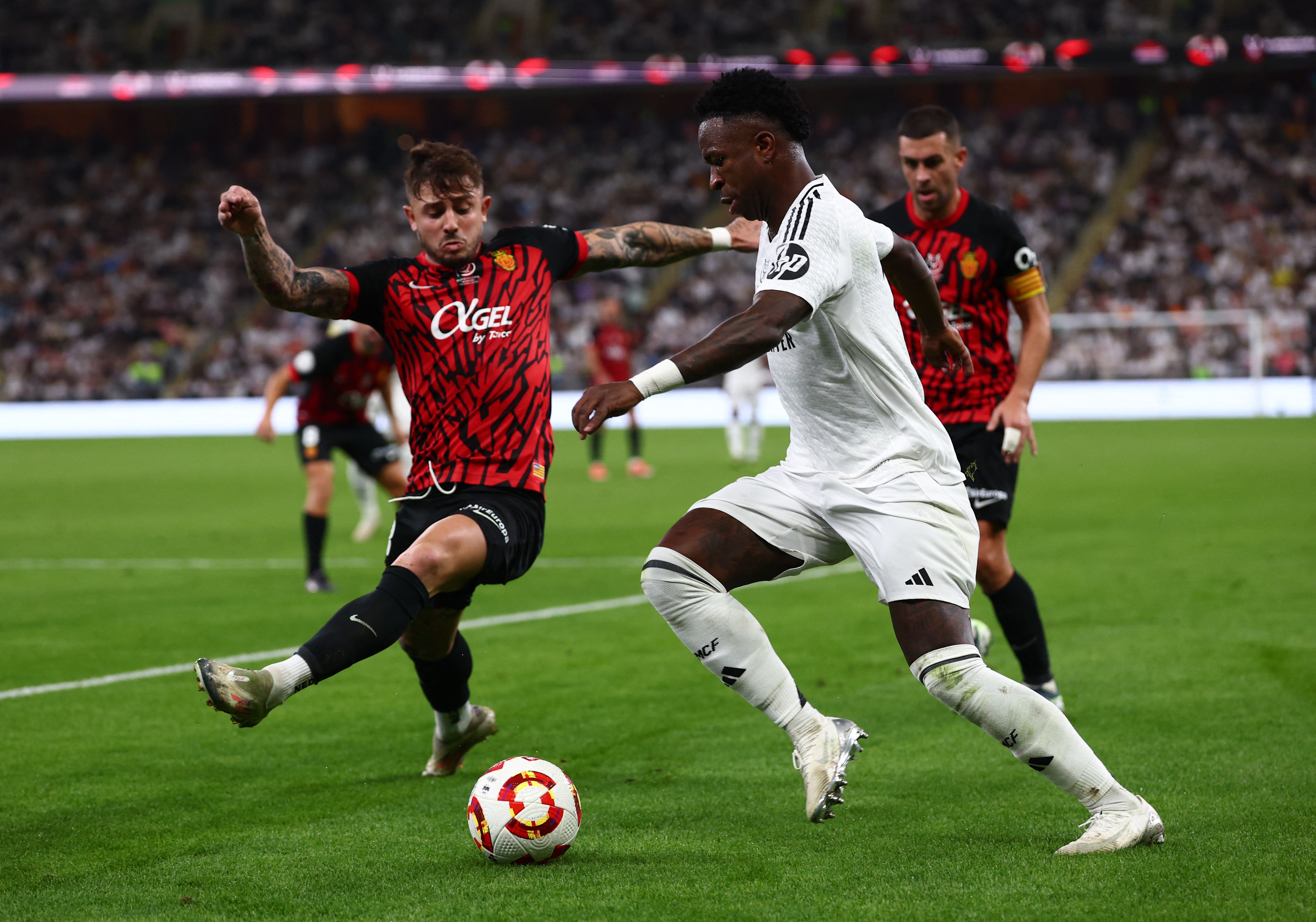 Soccer Football - Spanish Super Cup - Semi Final - Real Madrid v RCD Mallorca - King Abdullah Sports City, Jeddah, Saudi Arabia - January 9, 2025 Real Madrid's Vinicius Junior in action with RCD Mallorca's Pablo Maffeo REUTERS/Pedro Nunes