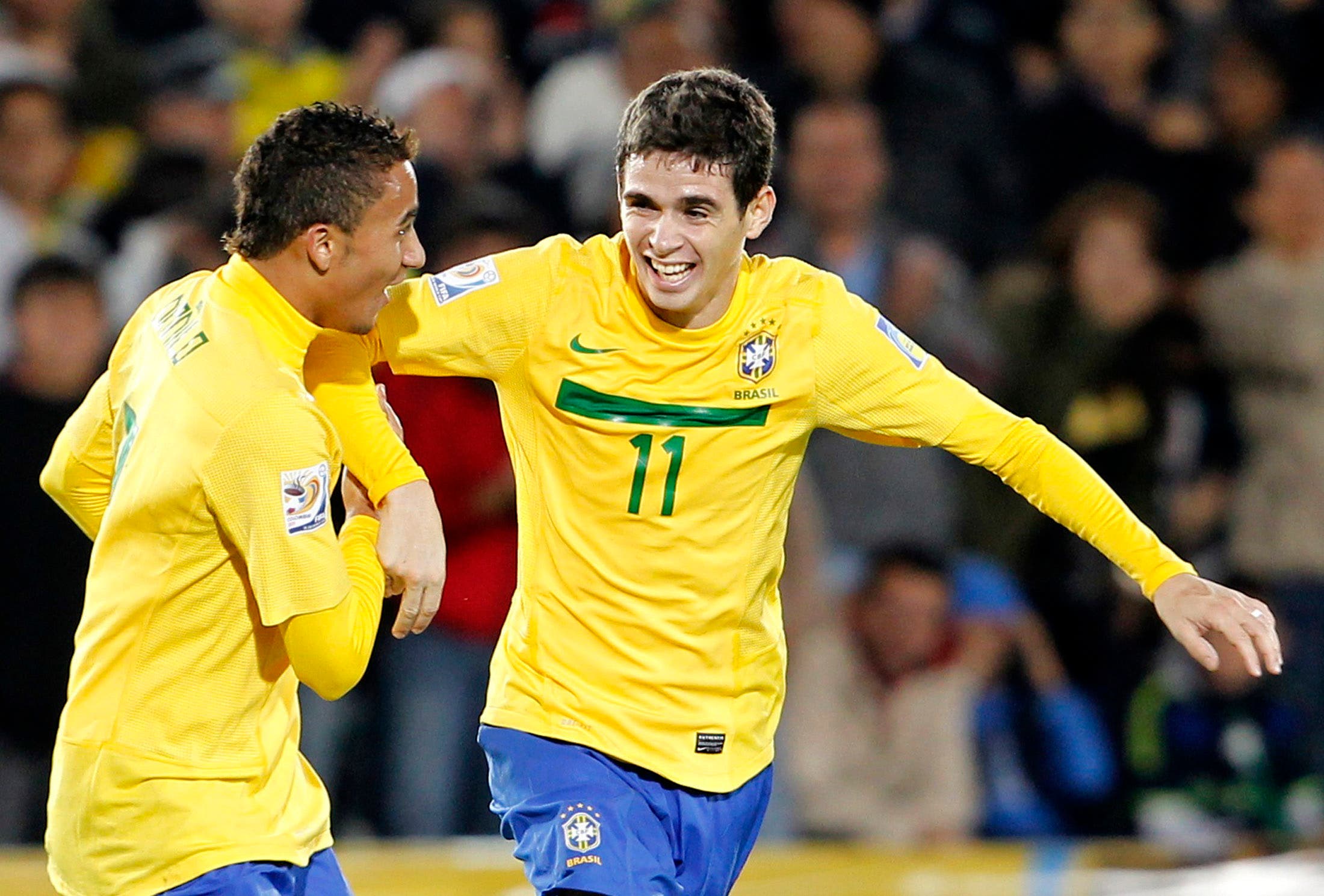 Brazil's Oscar (R) celebrates with teammate Danilo after scoring his team's third goal against Portugal during their FIFA U-20 World Cup final soccer match in Bogota, August 20, 2011. REUTERS/Jose Miguel Gomez (COLOMBIA - Tags: SPORT SOCCER)