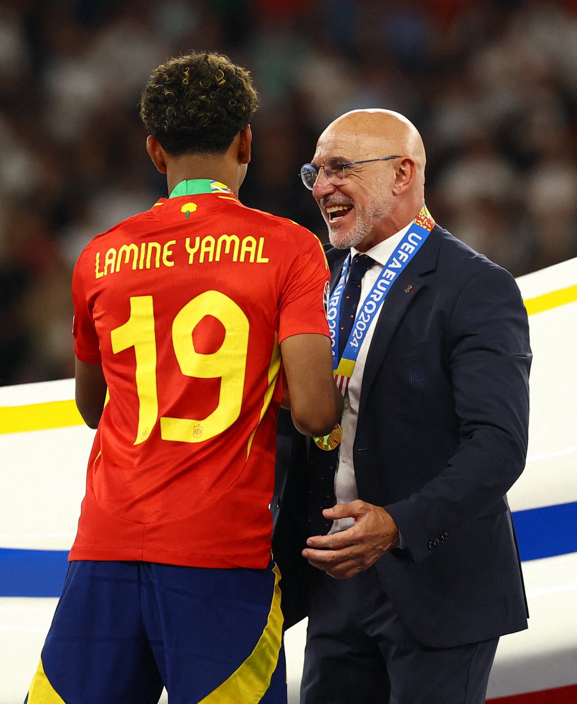 Spain coach Luis de la Fuente shakes hands with Spain's Lamine Yamal during the presentation