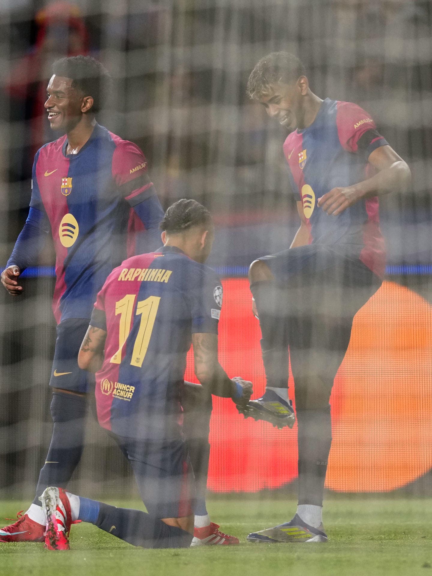 El delantero del Barcelona Lamine Yamal (d) celebra su gol contra el Benfica con el centrocampista brasileño del Barcelona Raphinha