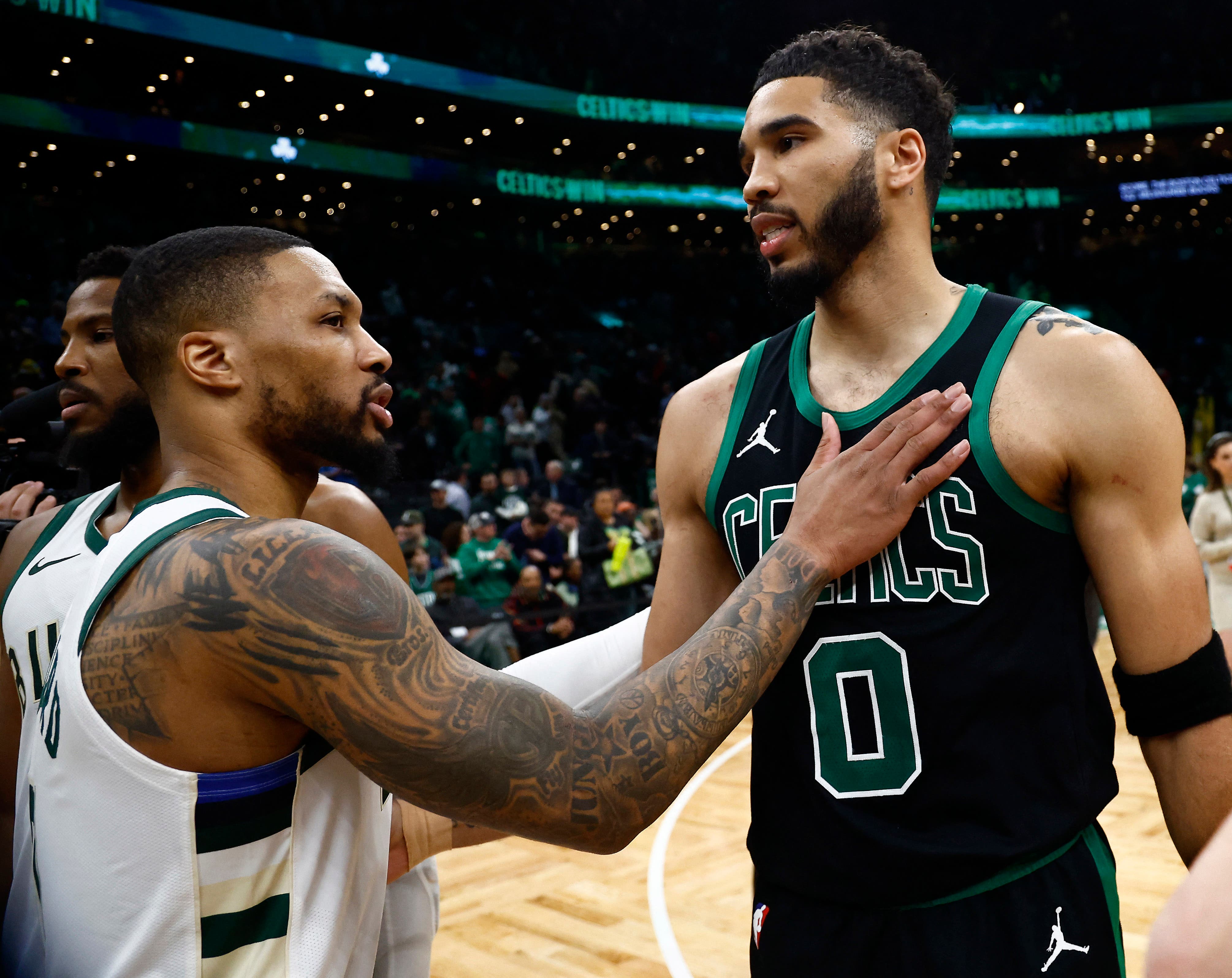 Jayson Tatum and Damian Lillard greeting each other at a Boston Celtics v Milwaukee Bucks match in 2024.