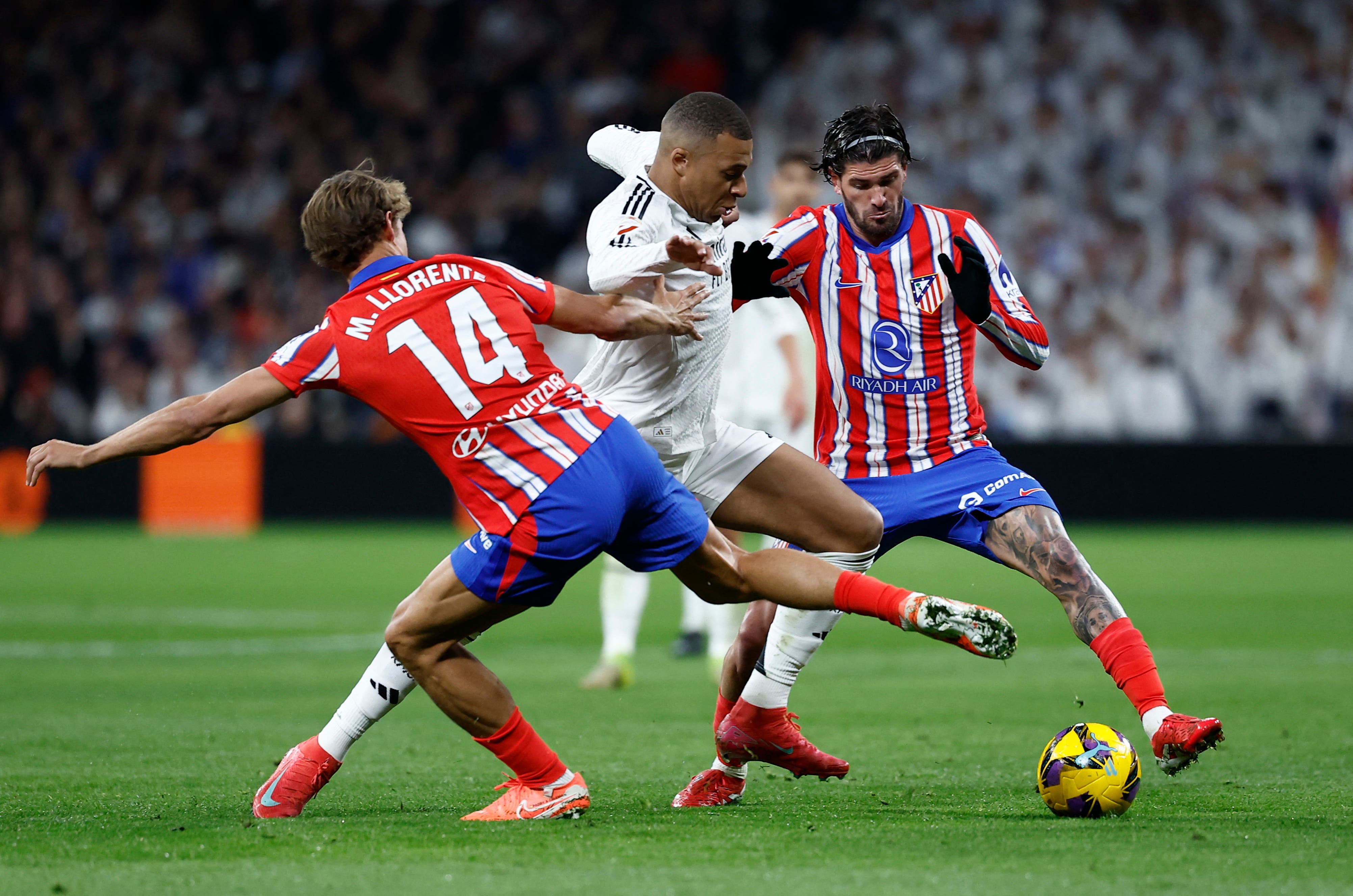 Kylian Mbappé, Marcos Llorente and Rodrigo de Paul during a match between Atlético Madrid and Real Madrid.