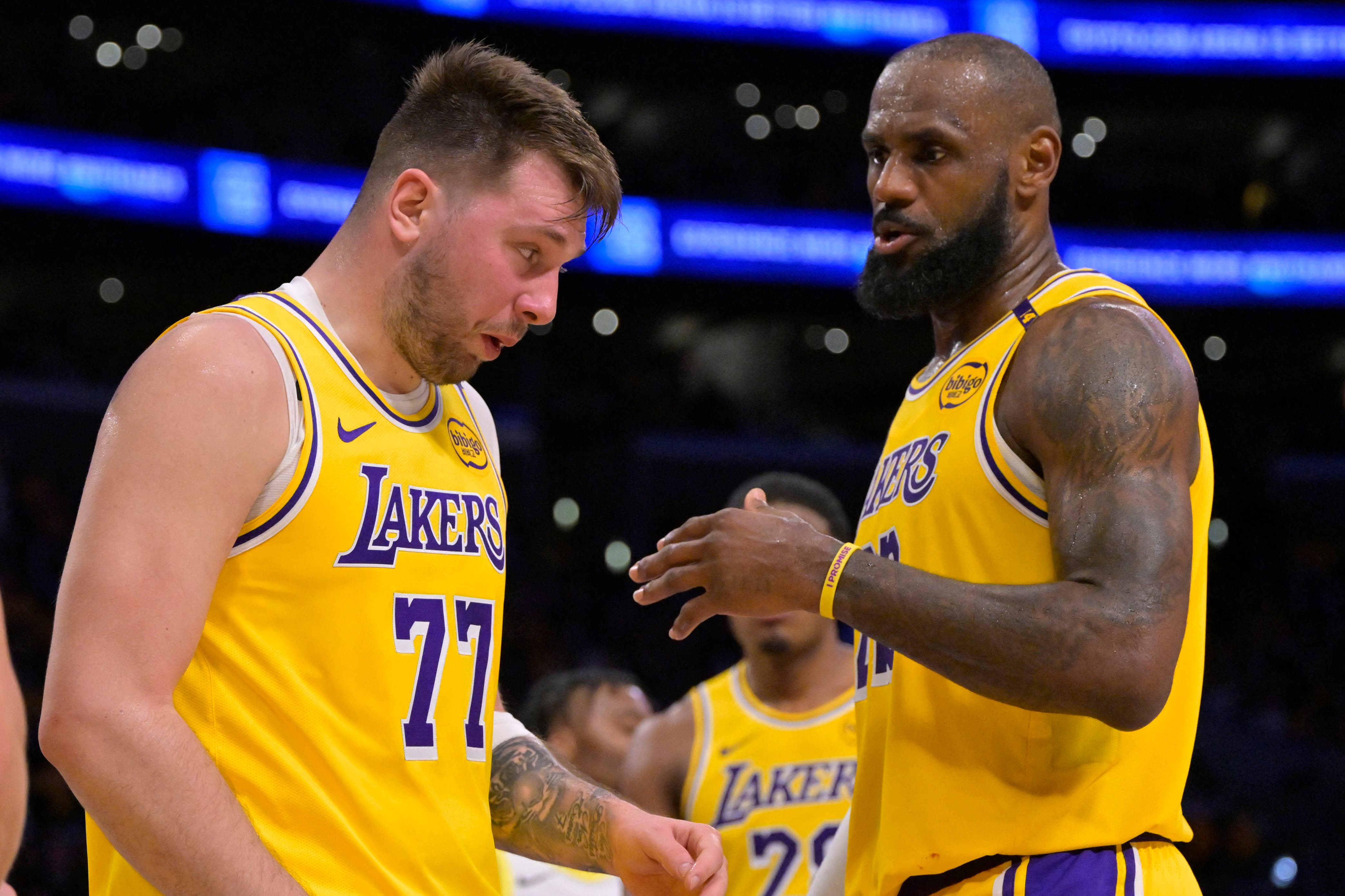 Los Angeles Lakers forward LeBron James (23) checks on guard Luka Doncic (77) after he was hit in the face against the Utah Jazz at Crypto.com Arena