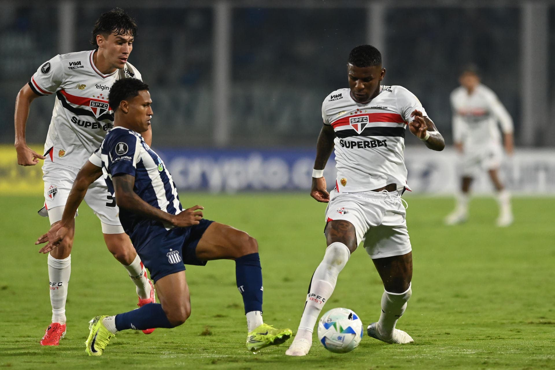 Rick (c) de Talleres disputa un balón con Robert Arboleda (d) de São Paulo