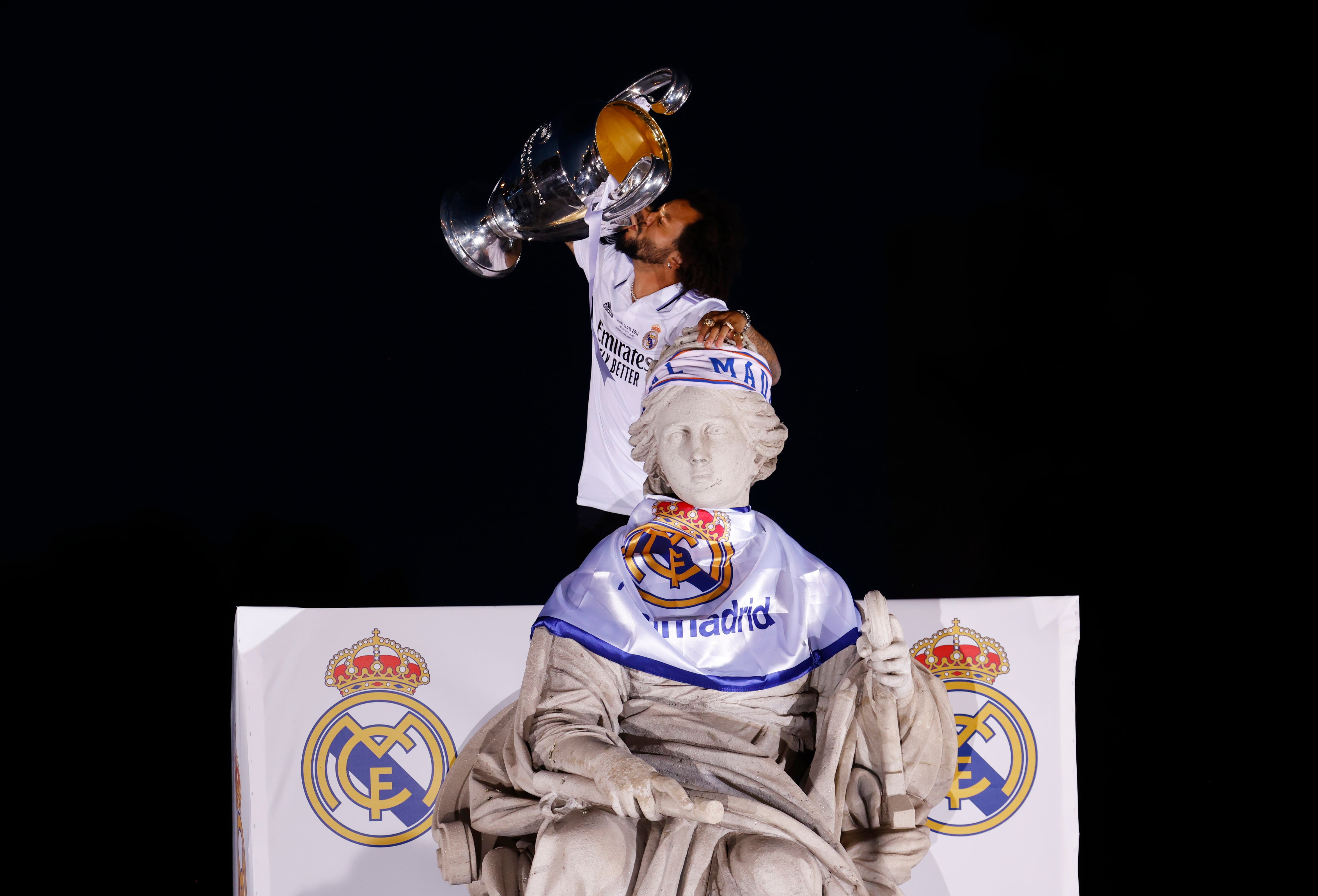 Real Madrid's Marcelo celebrates with the trophy at the fountain of Cibeles during the victory parade 