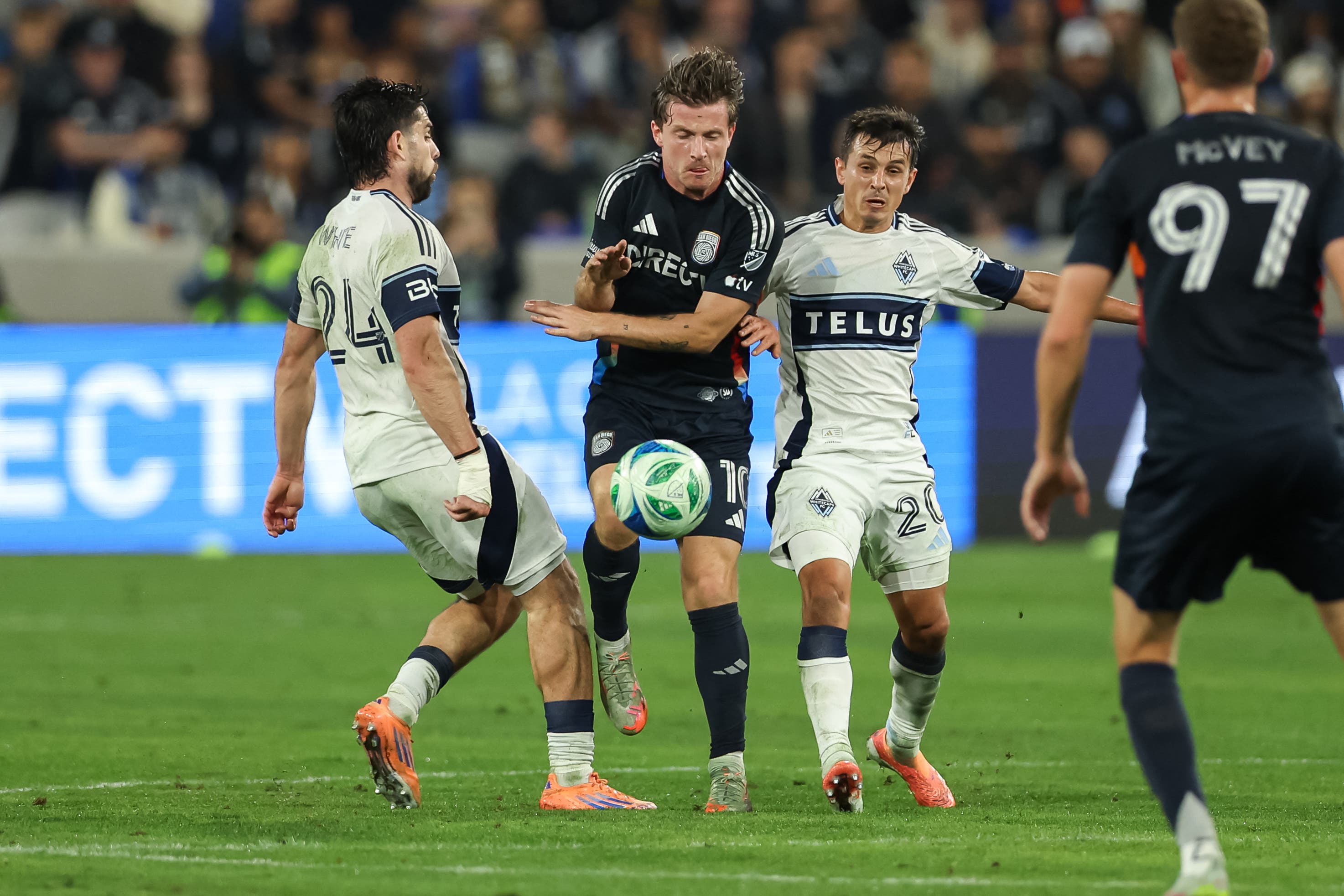 Nov 29, 2025; San Diego, California, USA; San Diego FC midfielder Anders Dreyer (10) competes for control with Vancouver Whitecaps forward Brian White (24) and midfielder Andres Cubas (20) during the first half at Snapdragon Stadium. Mandatory Credit: Chadd Cady-Imagn Images