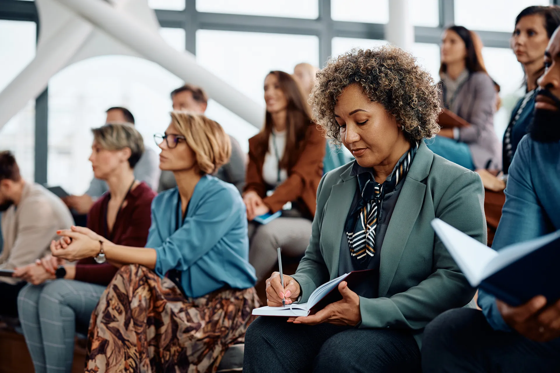 Businesswoman taking notes while participating in an education event