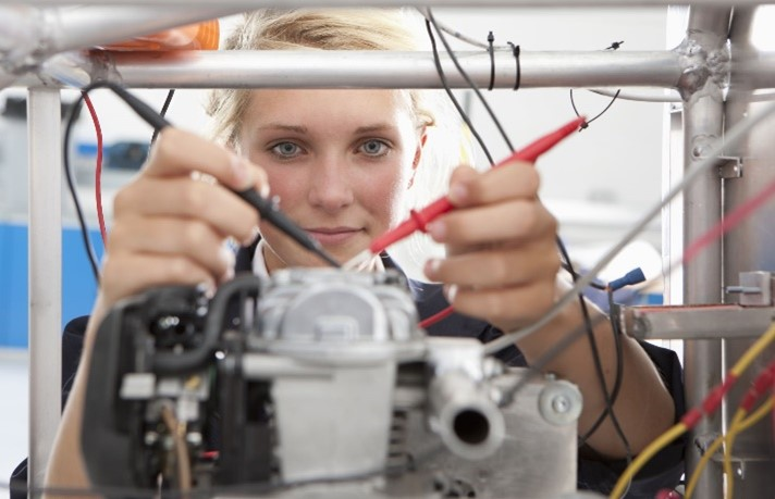 Female engineer in a lab, looking at equipment.