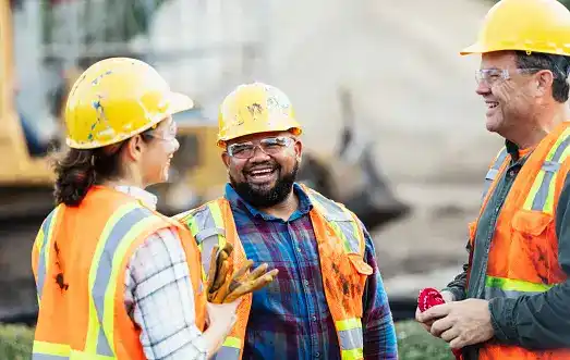 Three engineers laughing together.