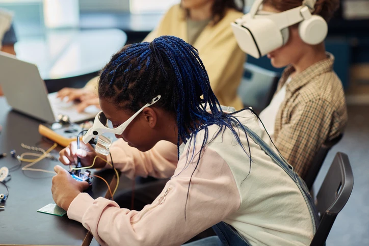 A child working with electrical wires wearing a VR-headset.