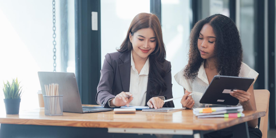 Two professionals sitting at a table reviewing notes