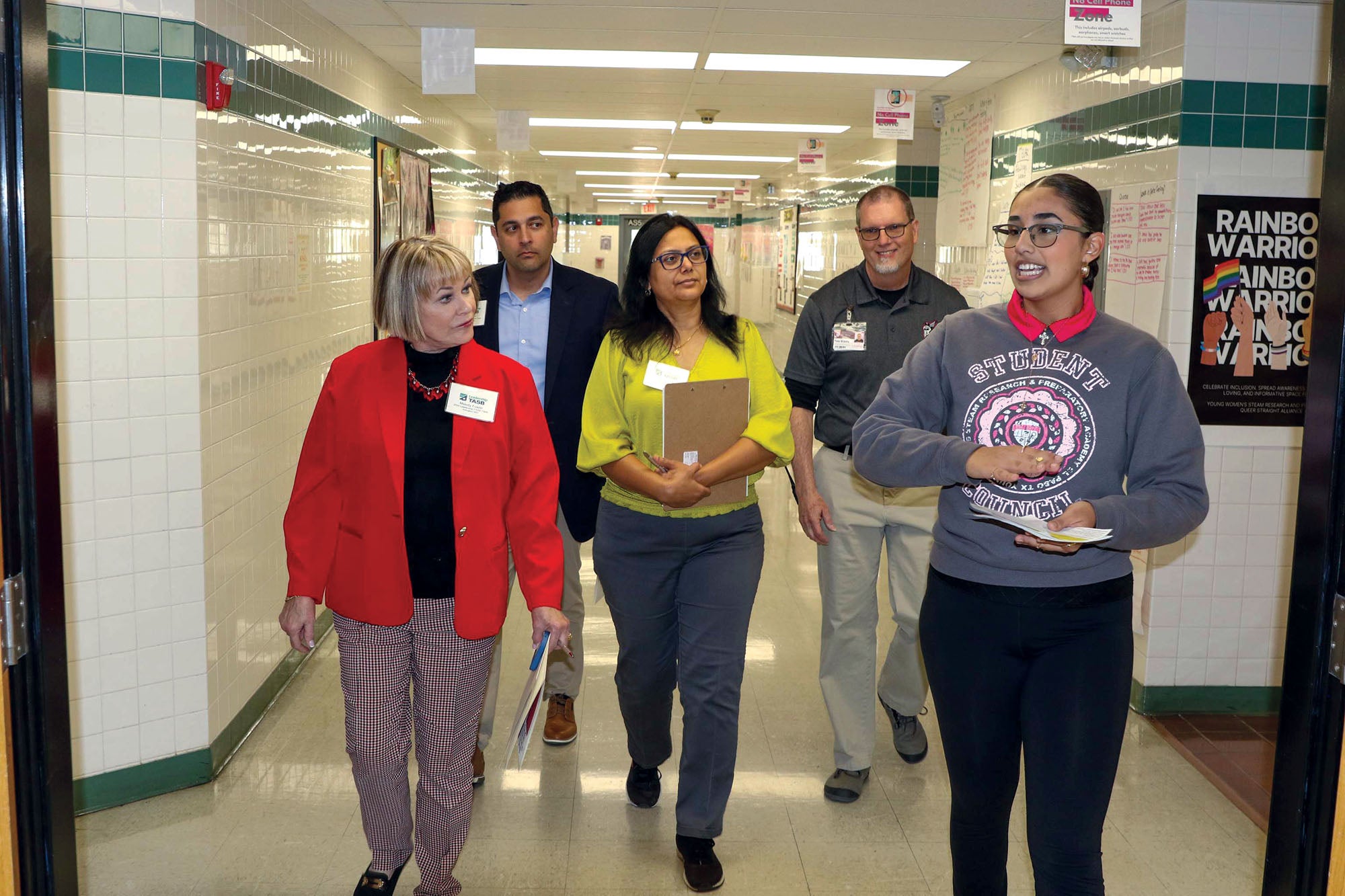 A student council member leads LTASB members on a tour of their school.