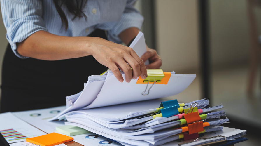 photo of woman going through stacks of documents