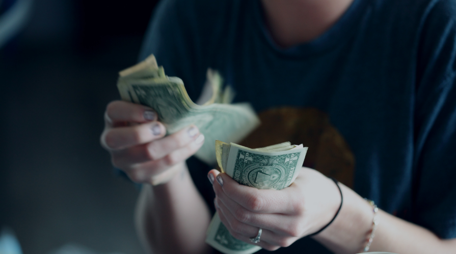 photo of a female counting dollar bills in her hand