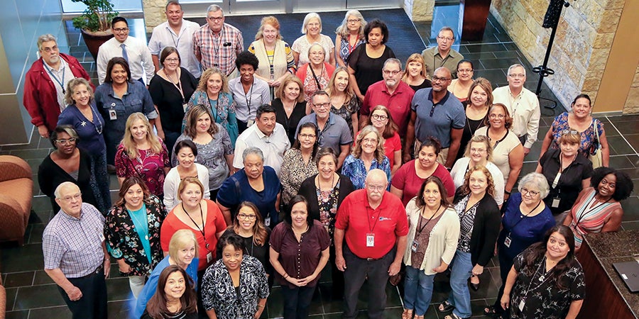 TASB Risk Management Services claims staff pose for a photo in the lobby of TASB Headquarters in 2018.
