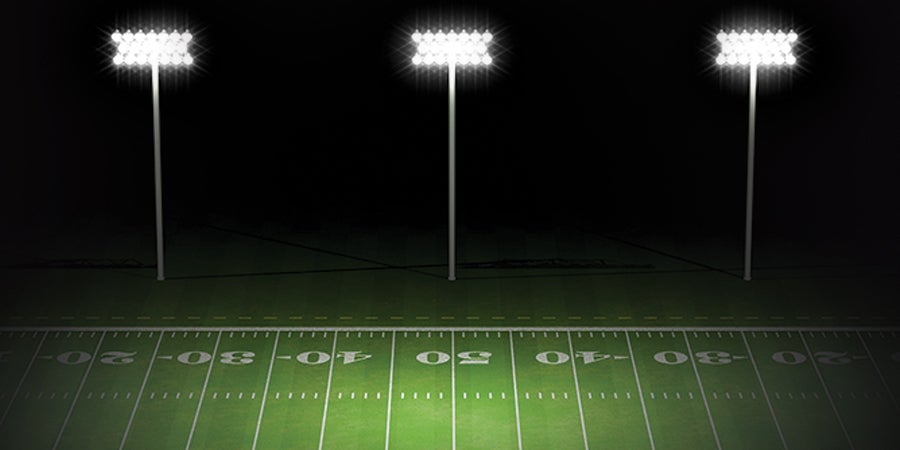 Bright lights shining on a high school football field at night