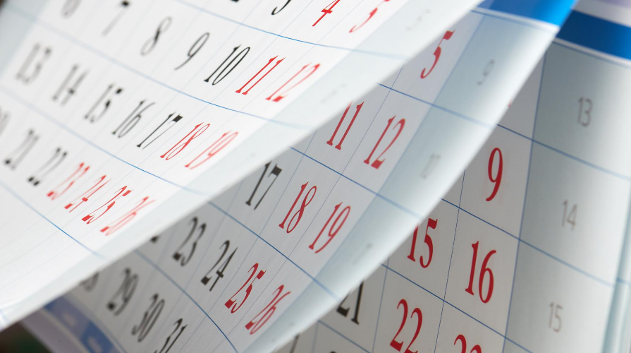 Large pages of a calendar hanging from a wall.