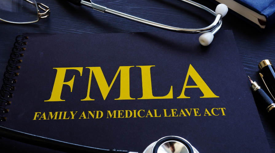 photo of a blue notebook with the following yellow title: FMLA Family and Medical Leave Act