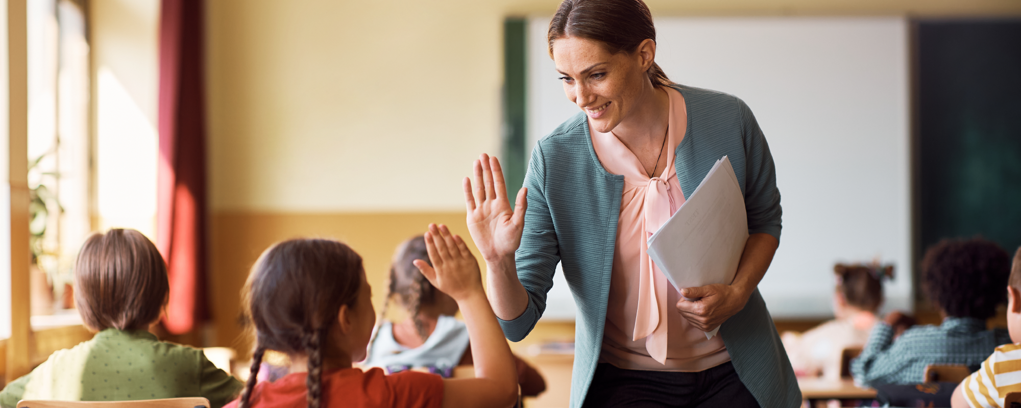 Teacher giving student a high five in classroom