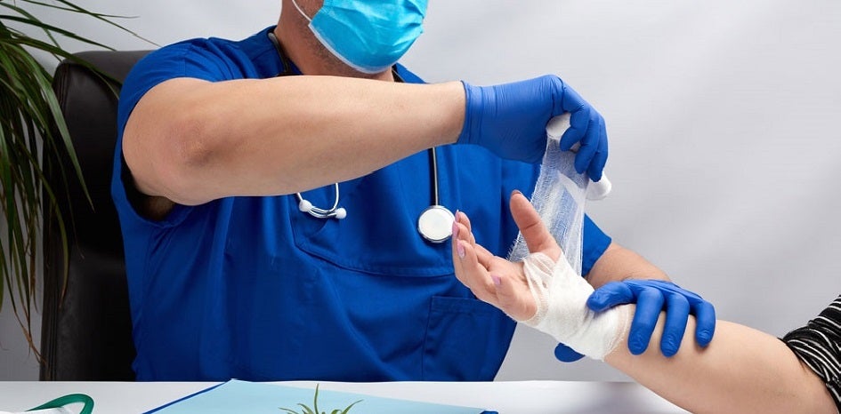 Medical professional wrapping an injured wrist.