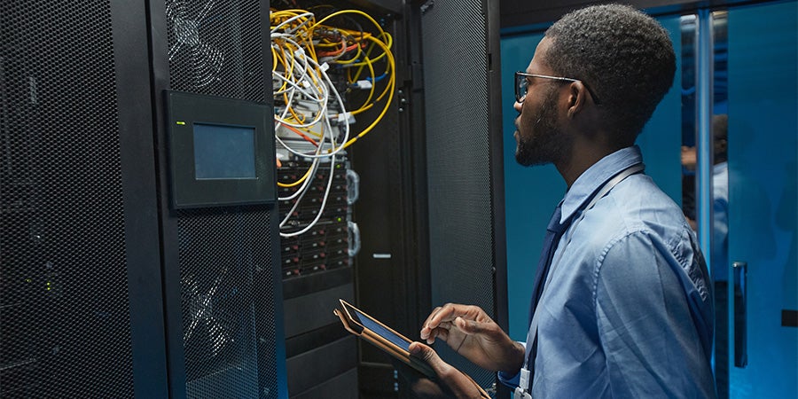 Man investigating wires in server room