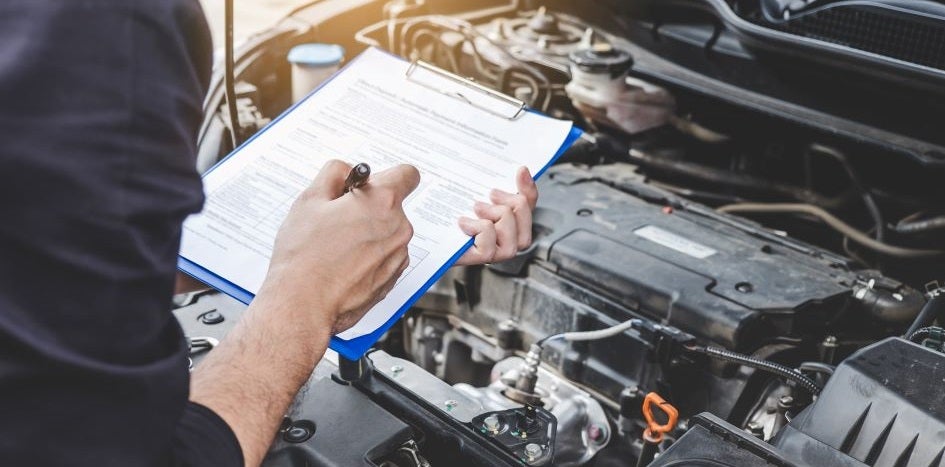 Man with a clipboard over an engine