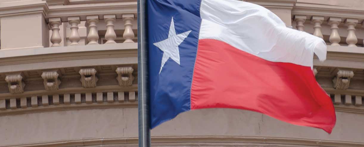 Texas flag waving outside of the Capitol building